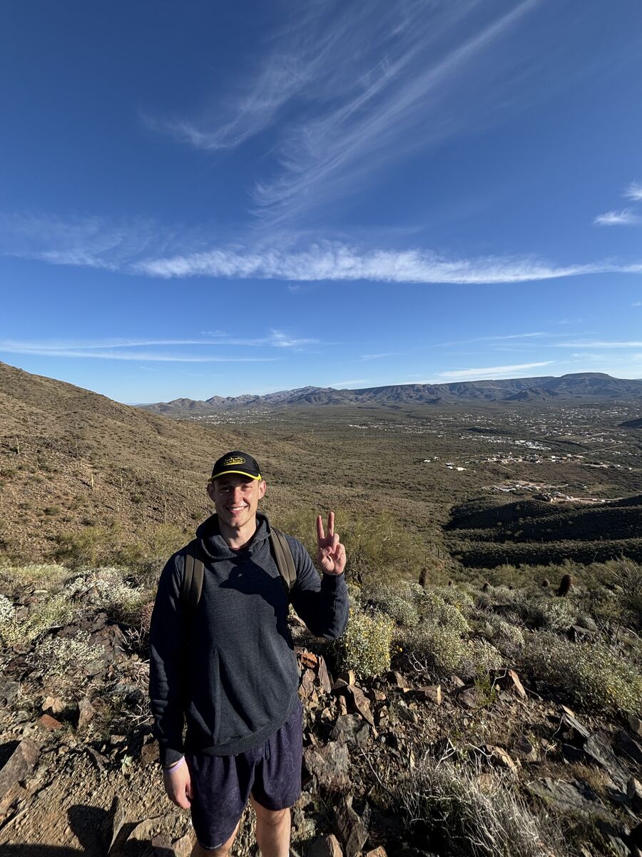 Josh hiking on a mountain summit
